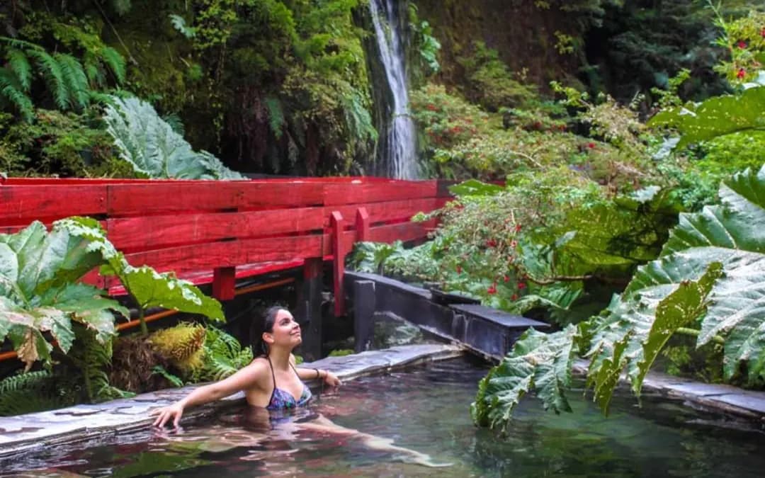 Pasarelas rojas y pozones naturales de las Termas Geométricas en el bosque nativo