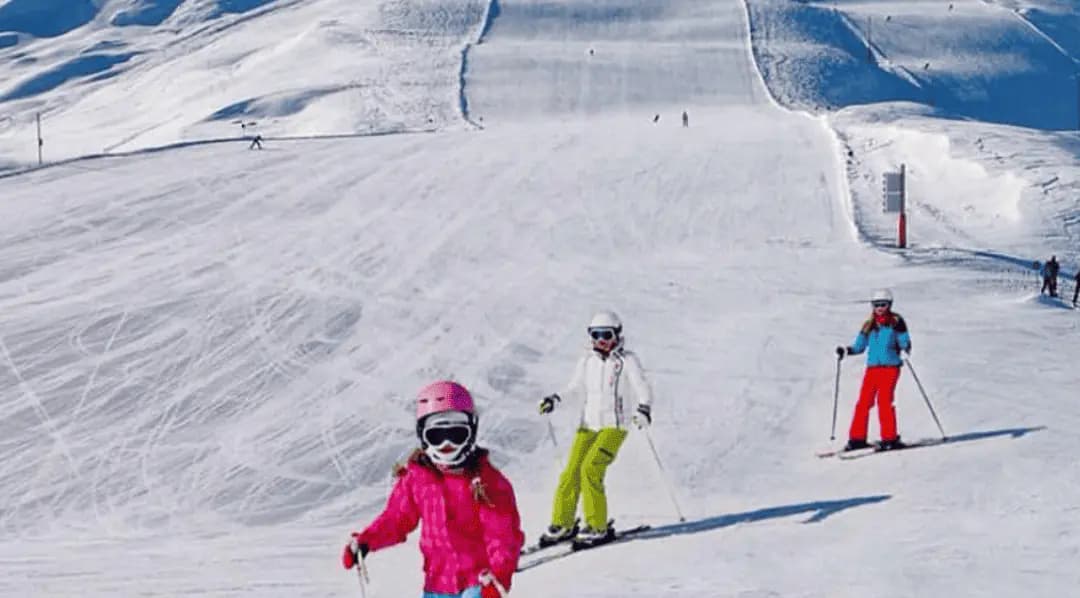 Familia esquiando en una pista ancha de Valle Nevado